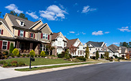 Street of large suburban homes on sunny day